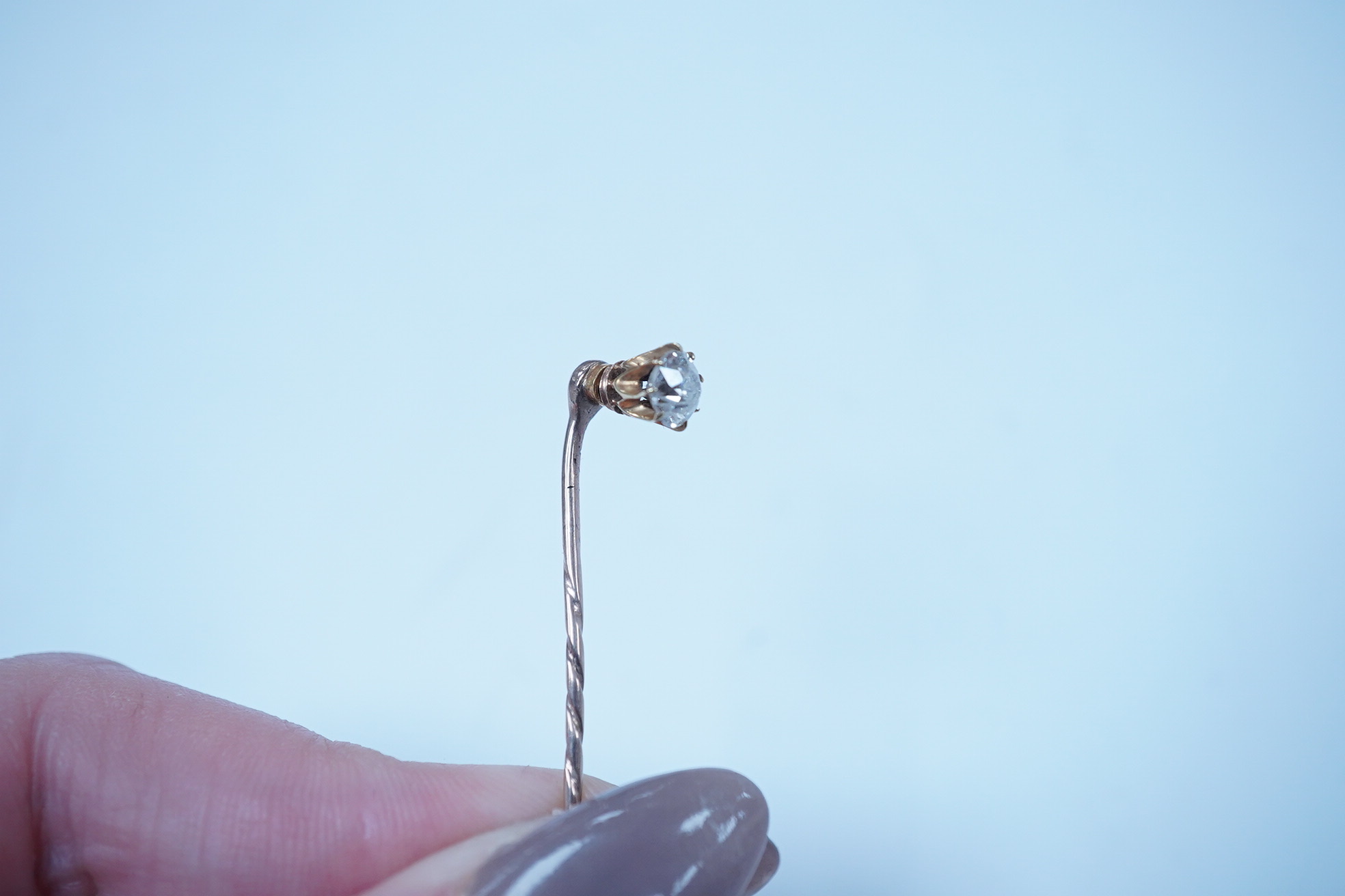 A yellow metal and solitaire diamond set stick pin, the stone diameter approx. 5mm, 59mm, gross weight 2.3 grams. Condition - fair to good